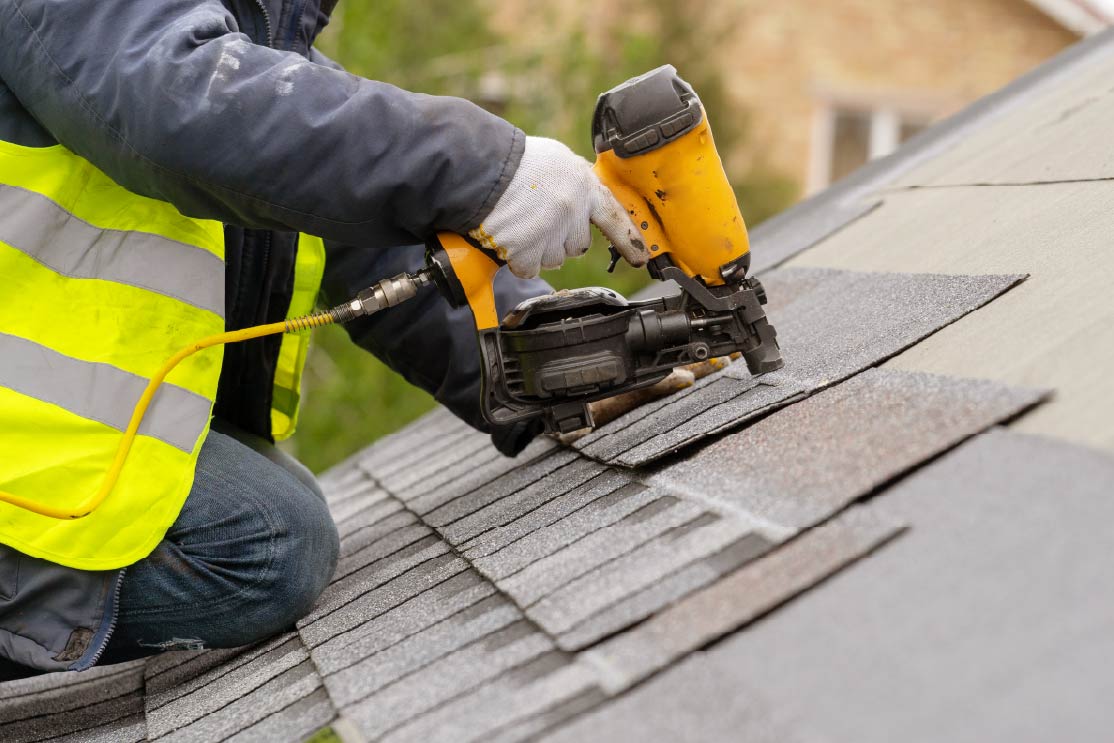 construction worker installing shingles